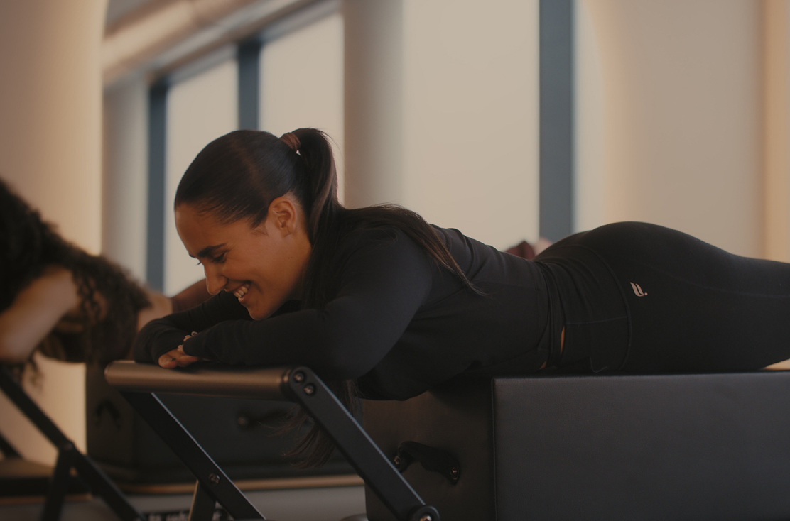 TUBA member smiling on a reformer
